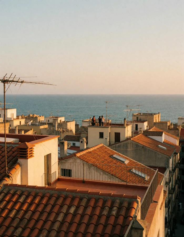 Barcelona rooftops and Mediterranean coastline seen from an elevated terrace at golden hour