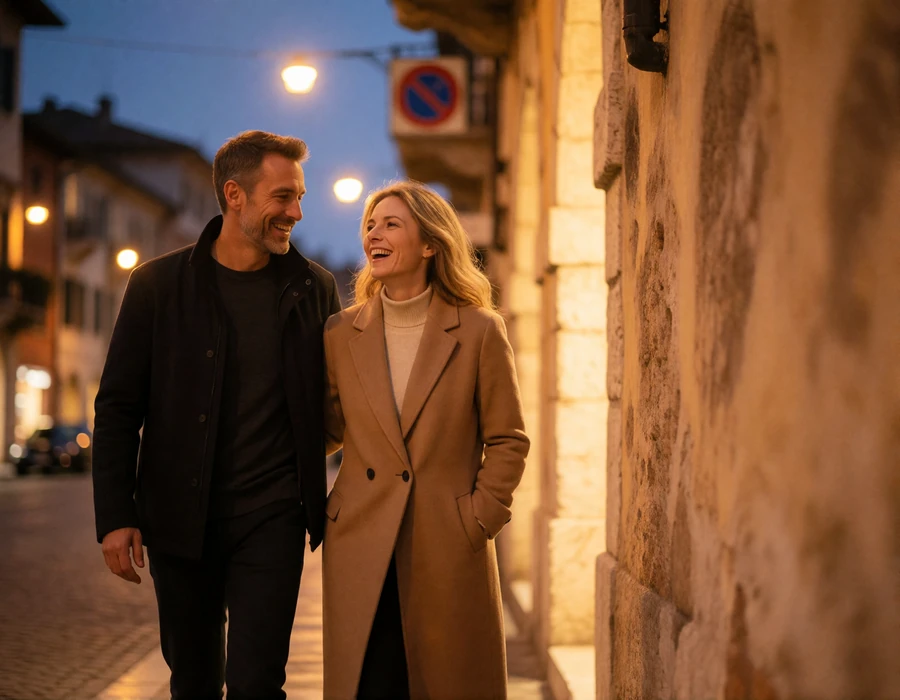 Couple in their forties walking and laughing along a Verona street at dusk